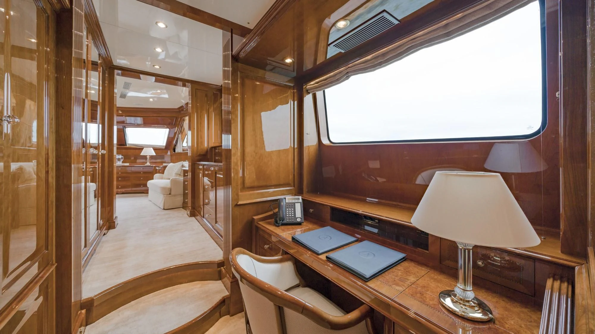 a room with a desk and a lamp aboard AURA Yacht for Sale