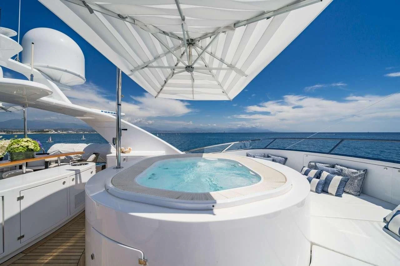 a large white boat on a body of water aboard AURA Yacht for Sale