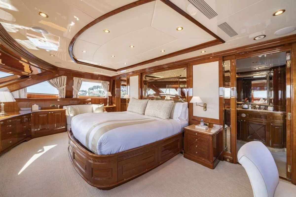 a bedroom with a bed and a mirror aboard AURA Yacht for Sale