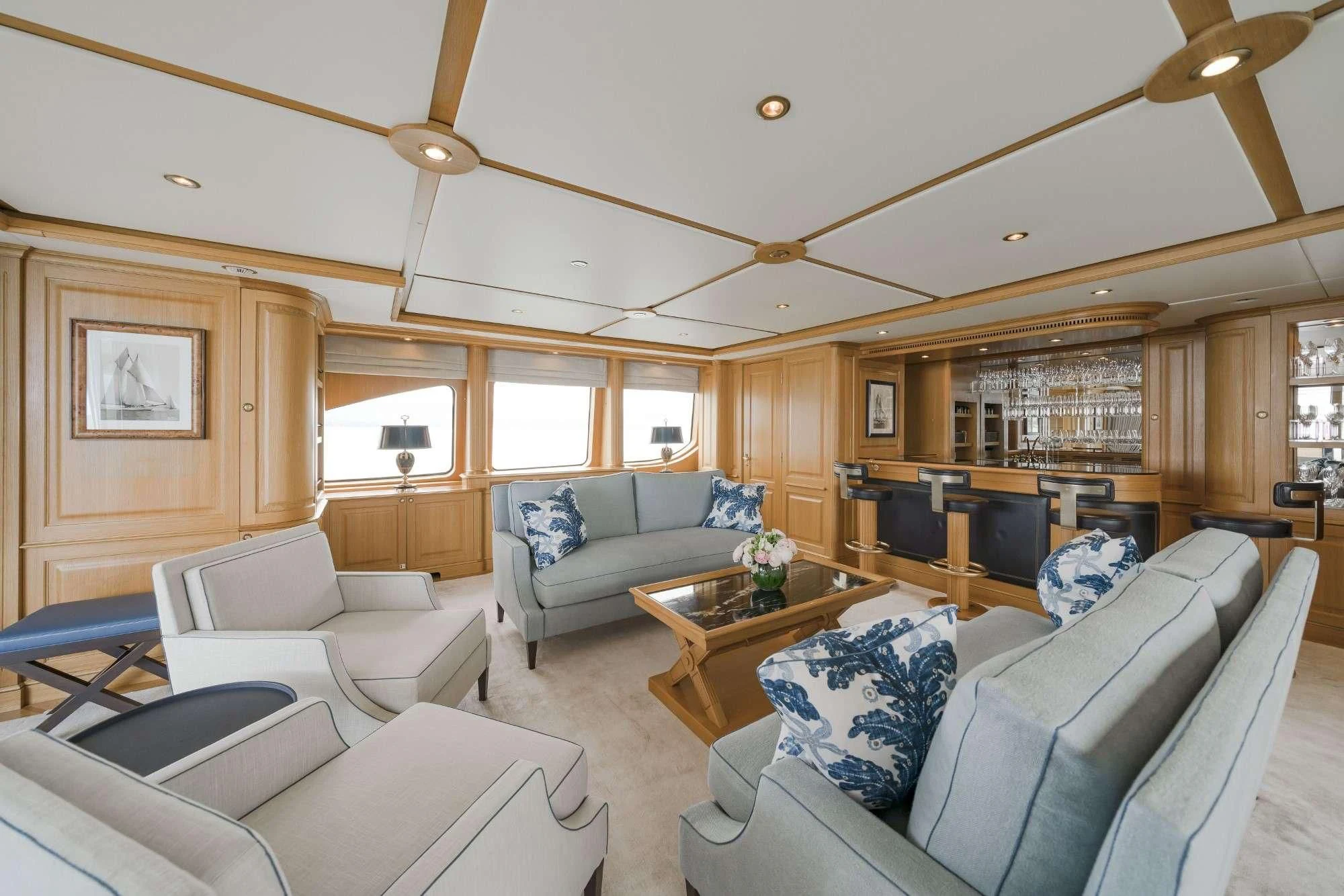 a living room with a couch and a coffee table aboard AURA Yacht for Sale