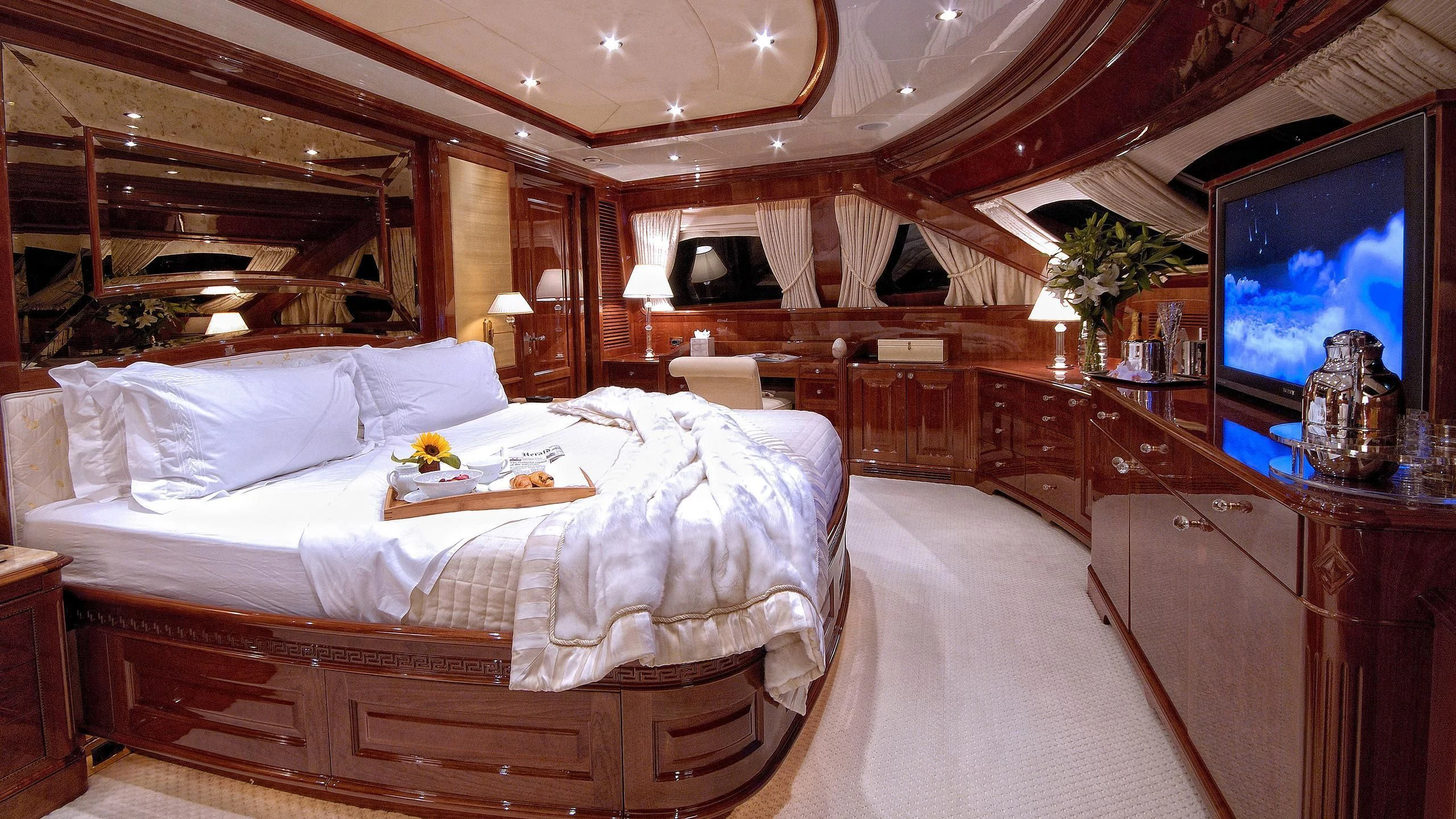 a room with a bed and a television aboard AURA Yacht for Sale