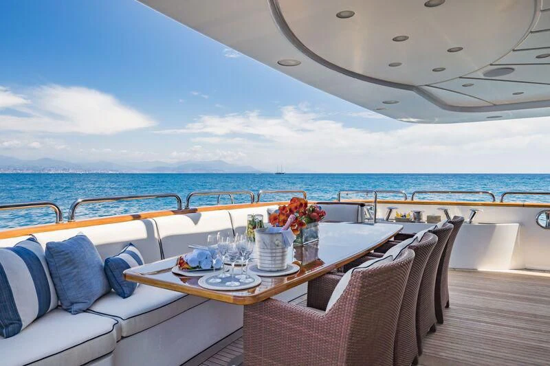 a table on a deck overlooking the ocean aboard AURA Yacht for Sale