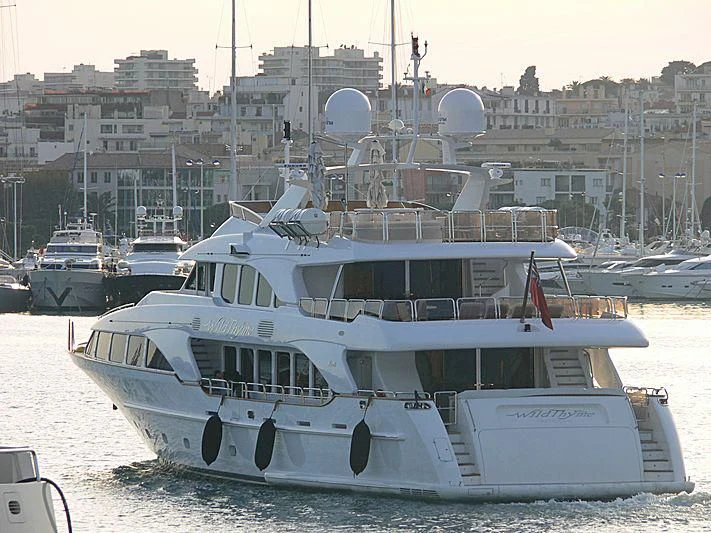 a white yacht in a harbor aboard AURA Yacht for Sale