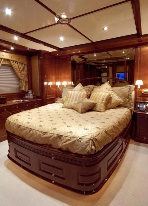 a bed with a large mirror above it aboard AURA Yacht for Sale