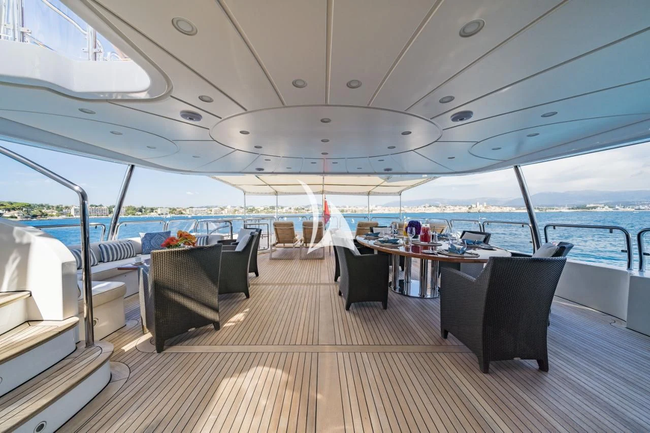 a deck with a table and chairs on it aboard AURA Yacht for Sale