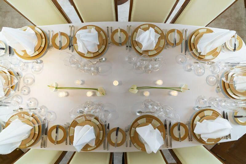 a table with glasses and plates aboard AURA Yacht for Sale