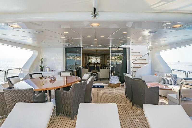 a room with tables and chairs aboard AURA Yacht for Sale