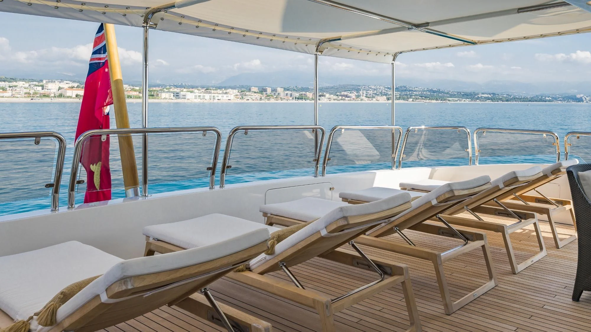 a boat with chairs and umbrellas aboard AURA Yacht for Sale