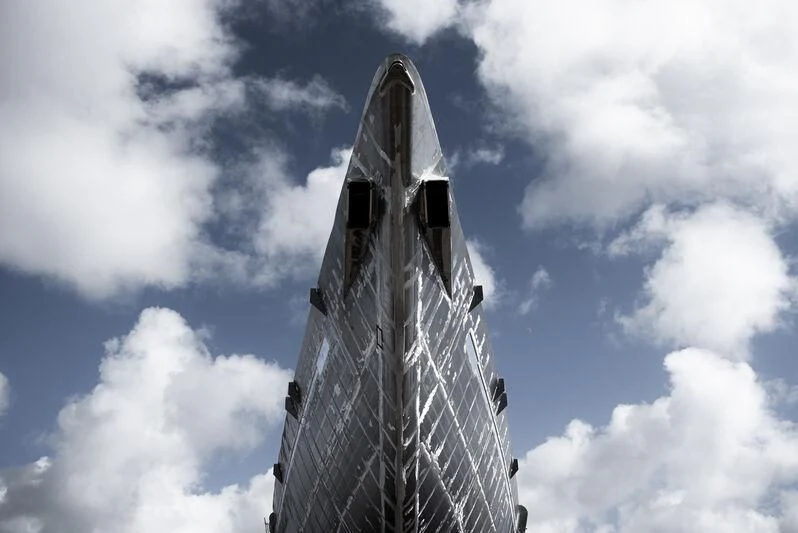 a tall tower with a cloudy sky aboard AQUARIUS Yacht for Sale
