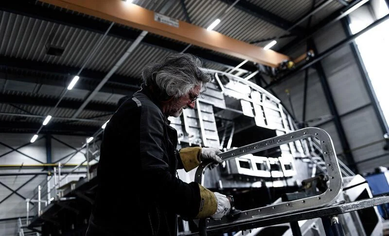 a man in a black coat fixing a machine aboard AQUARIUS Yacht for Sale