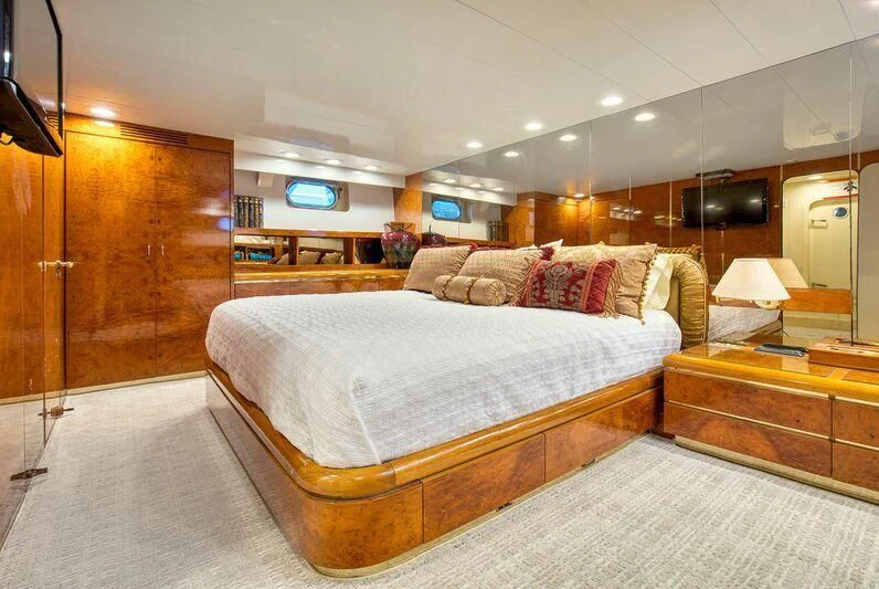a bedroom with a bed and a desk aboard LE CANARD Yacht for Sale