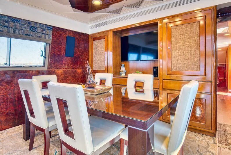a dining room with chairs and a table aboard LE CANARD Yacht for Sale