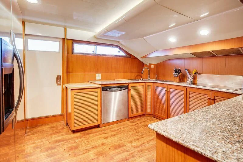 a kitchen with wooden cabinets aboard LE CANARD Yacht for Sale