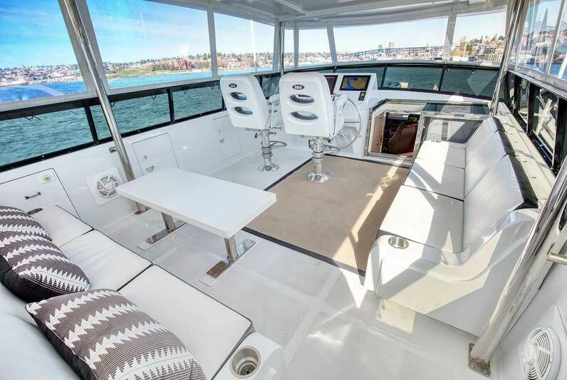 inside of a building with a large window and a table and chairs aboard LE CANARD Yacht for Sale