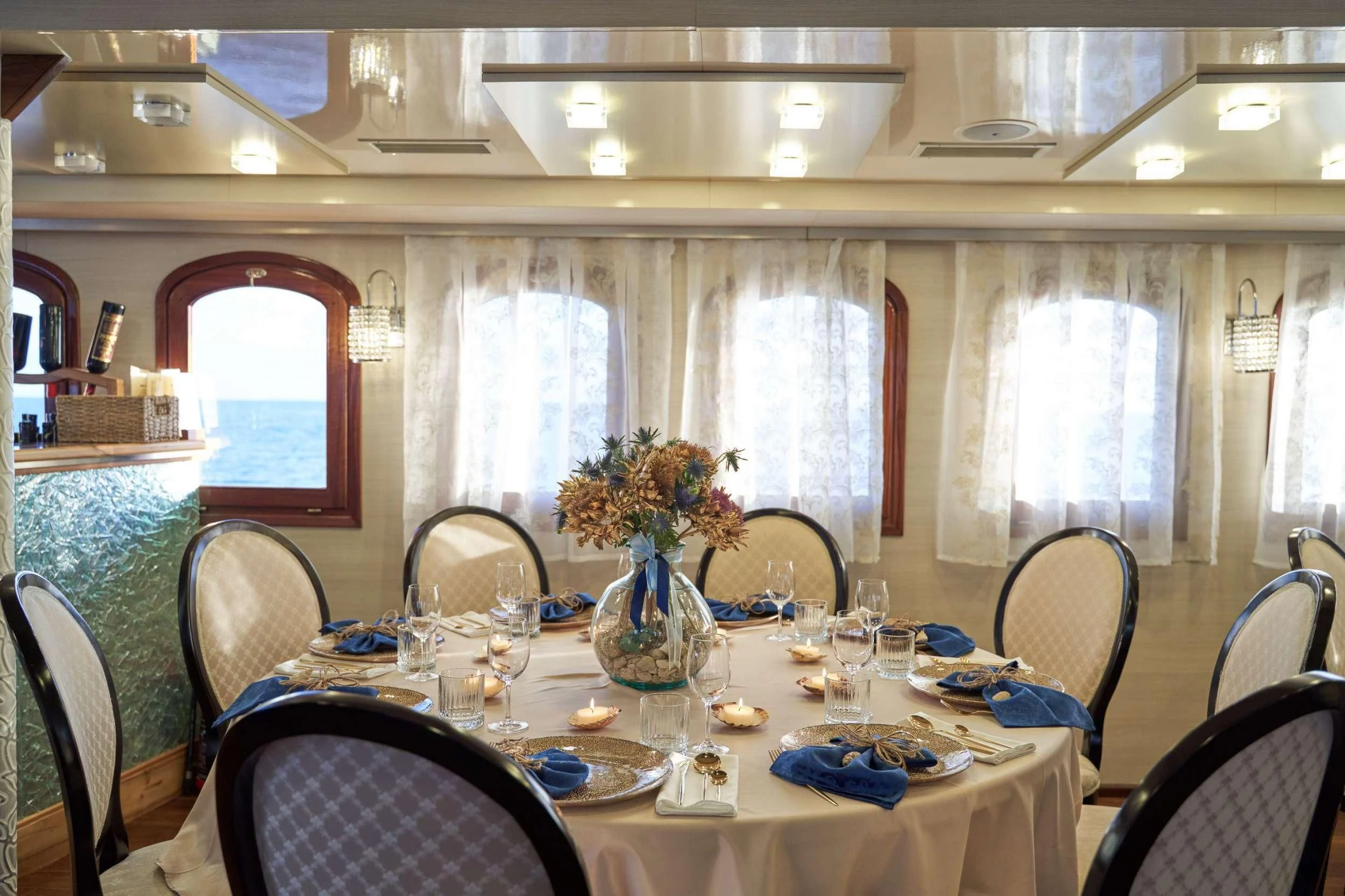 a dining room table with a vase of flowers and glasses aboard CASABLANCA Yacht for Sale
