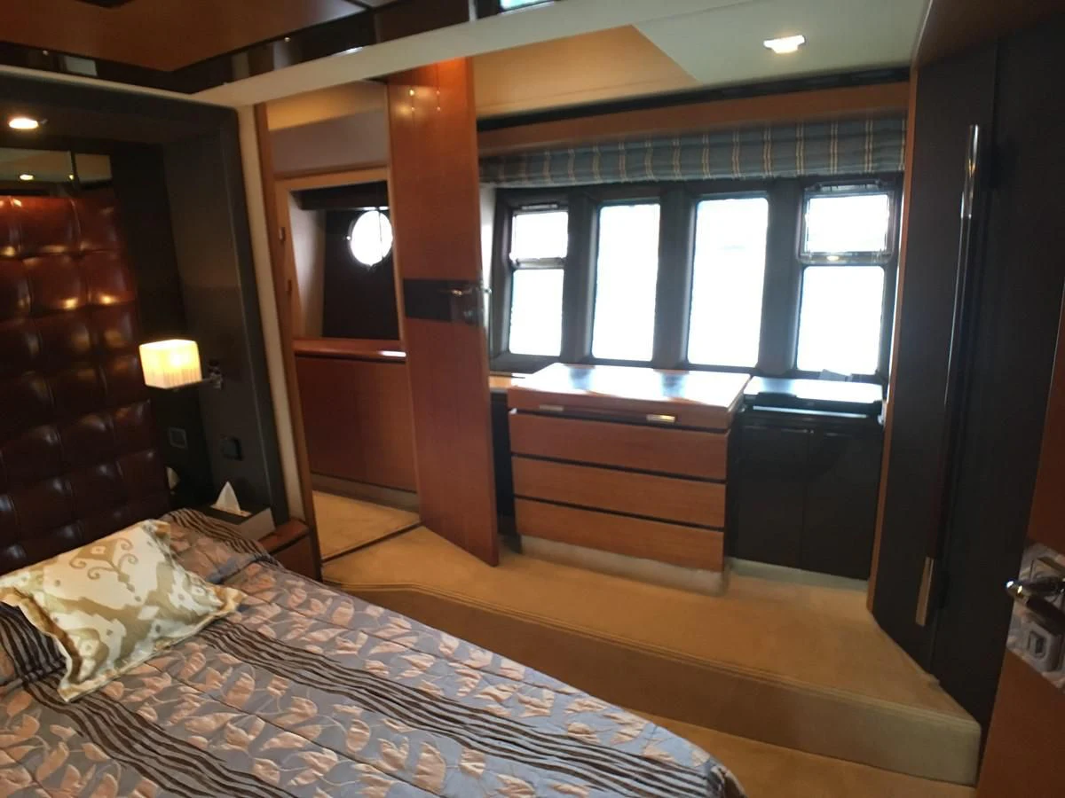 a bedroom with a bed and a dresser aboard AZIMUT 75 Yacht for Sale
