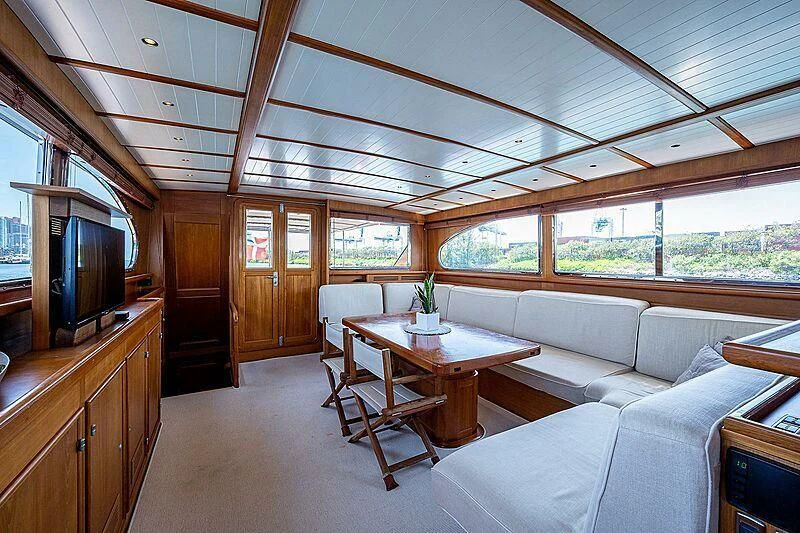 a living room with a table and couches aboard CABALLERO Yacht for Sale
