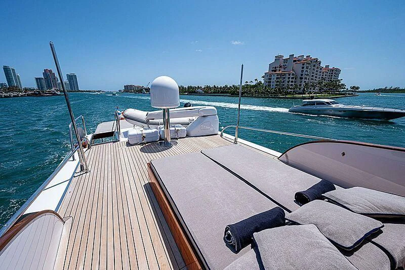 a deck with a boat and a large body of water in the background aboard CABALLERO Yacht for Sale