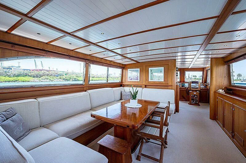 a living room with a table and couches aboard CABALLERO Yacht for Sale