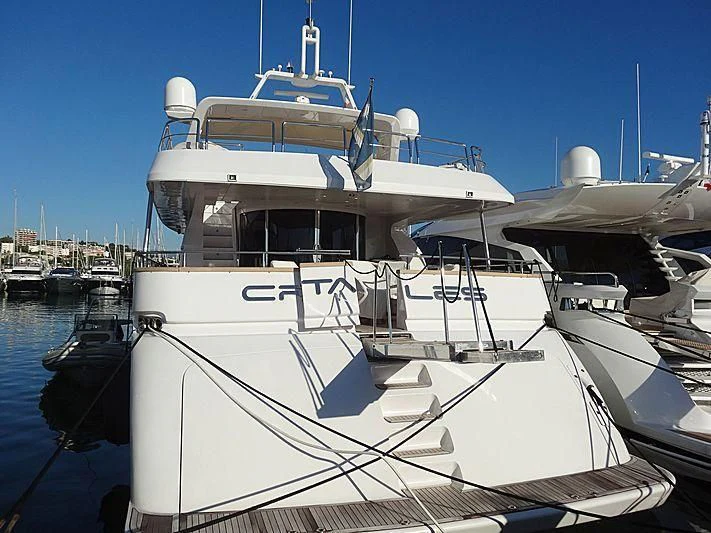 a large white boat in a harbor aboard CRISTALES Yacht for Sale
