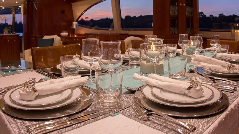 a table with plates and glasses aboard CRISTALES Yacht for Sale
