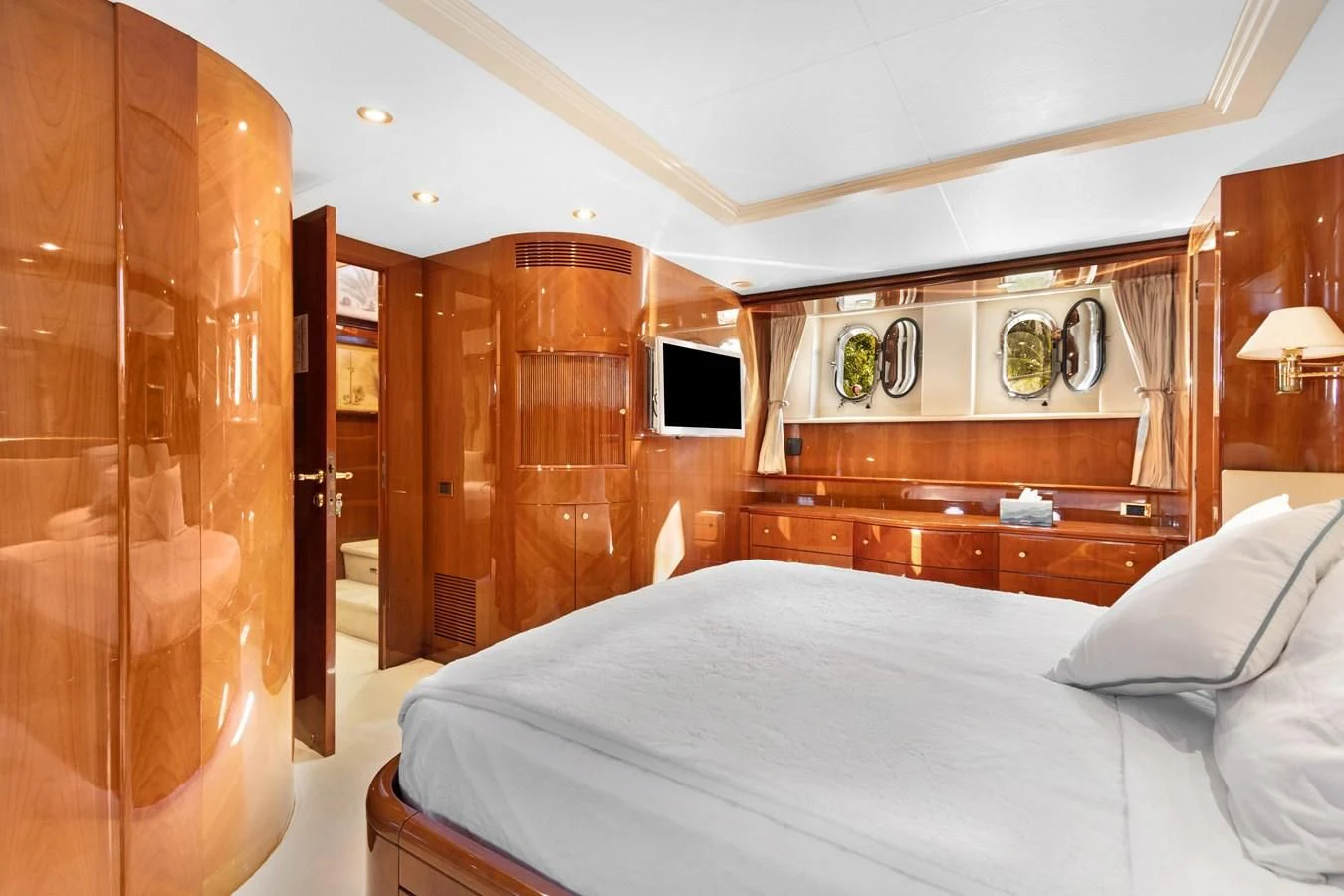 a bedroom with a bed and a wood cabinet aboard CRISTALES Yacht for Sale