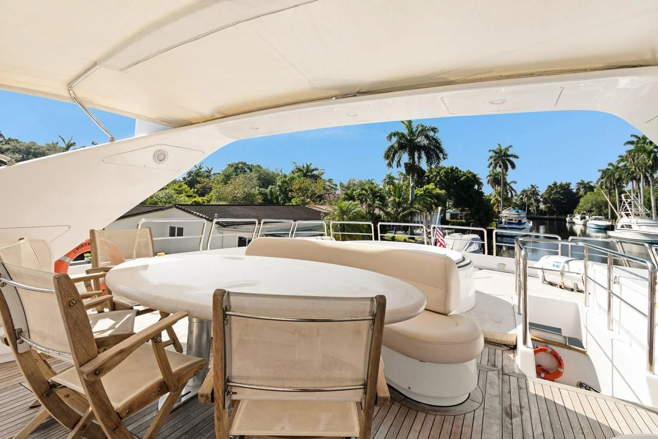 a lounge chair and tables on a deck with a large blue and white umbrella aboard CRISTALES Yacht for Sale