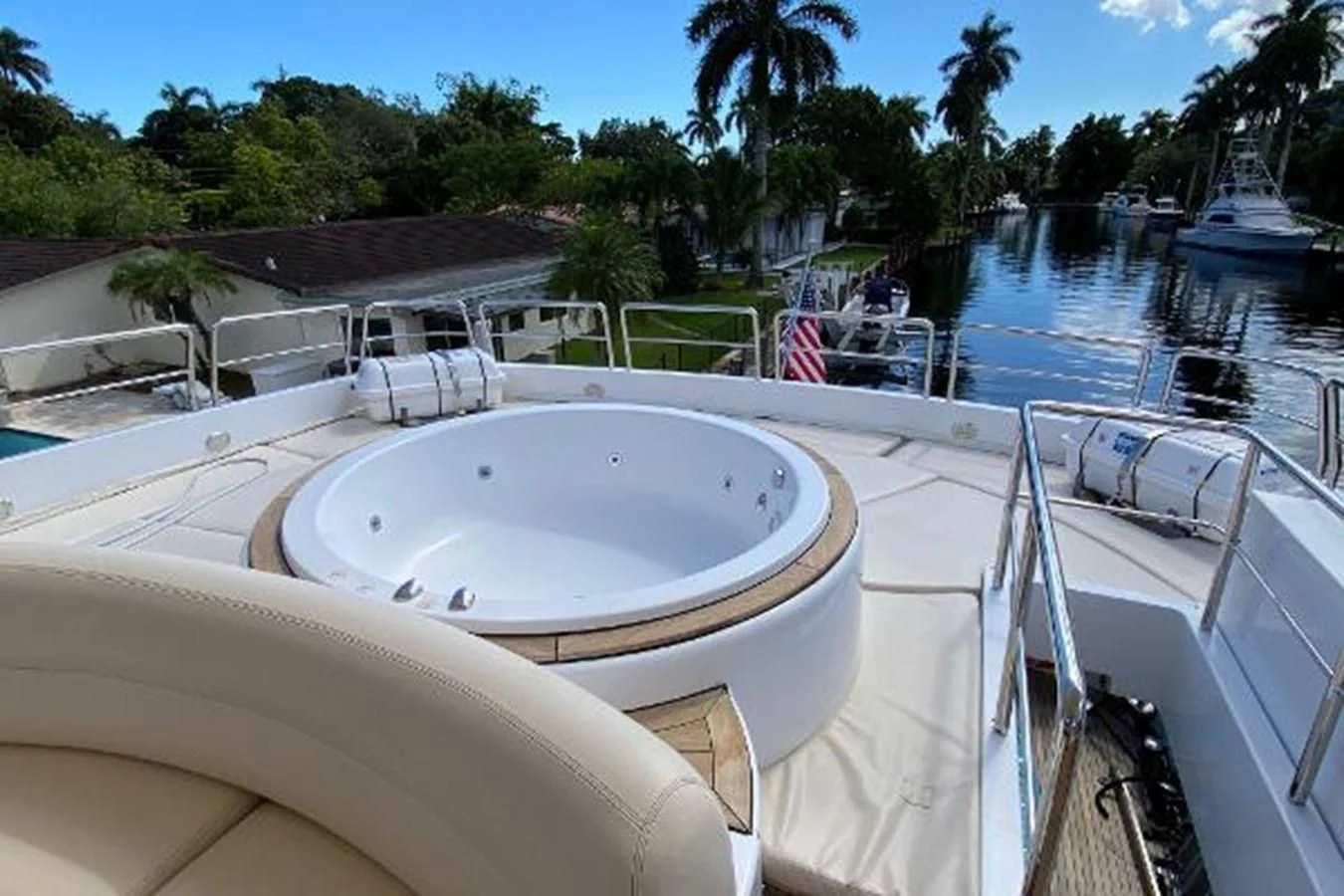 a pool with a large white round pool and a deck with chairs and trees and a building and aboard CRISTALES Yacht for Sale
