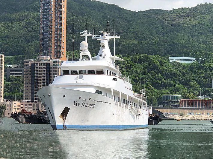 a large white boat in a harbor aboard VAN TRIUMPH Yacht for Sale