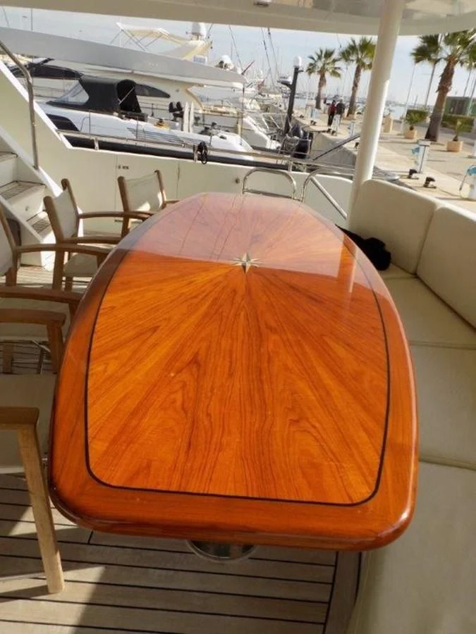 a wooden table with chairs aboard BENDIS Yacht for Sale