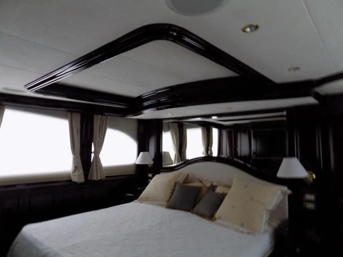 a bed with a white sheet and a black canopy over it aboard BENDIS Yacht for Sale