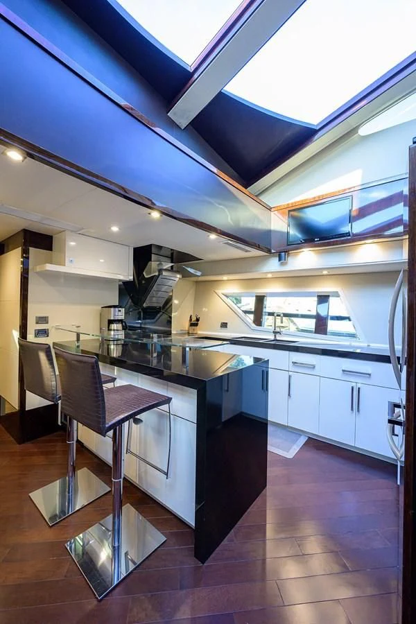 a kitchen with a bar and chairs aboard LADY NADIA Yacht for Sale