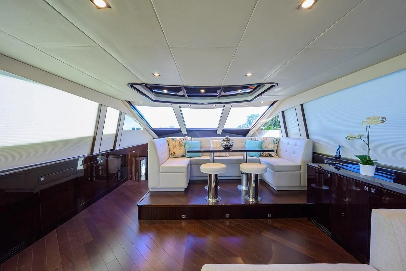 a room with a wood floor and a couch and a table with chairs aboard LADY NADIA Yacht for Sale