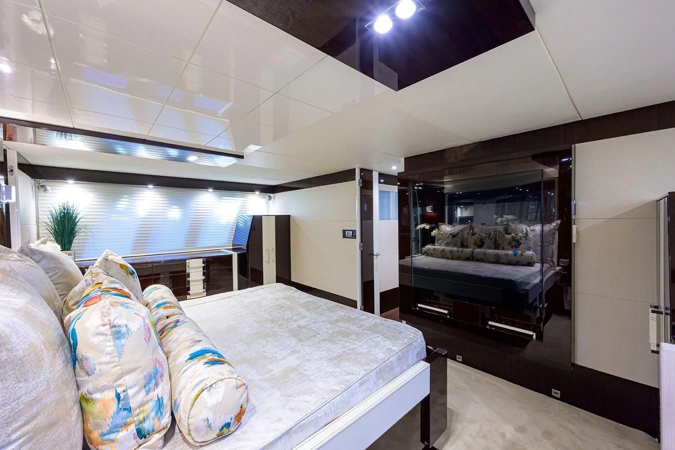 a bedroom with a bed and a large mirror aboard LADY NADIA Yacht for Sale