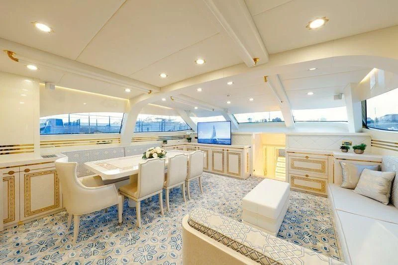a large room with a table and chairs aboard RUHUBELENT Yacht for Sale