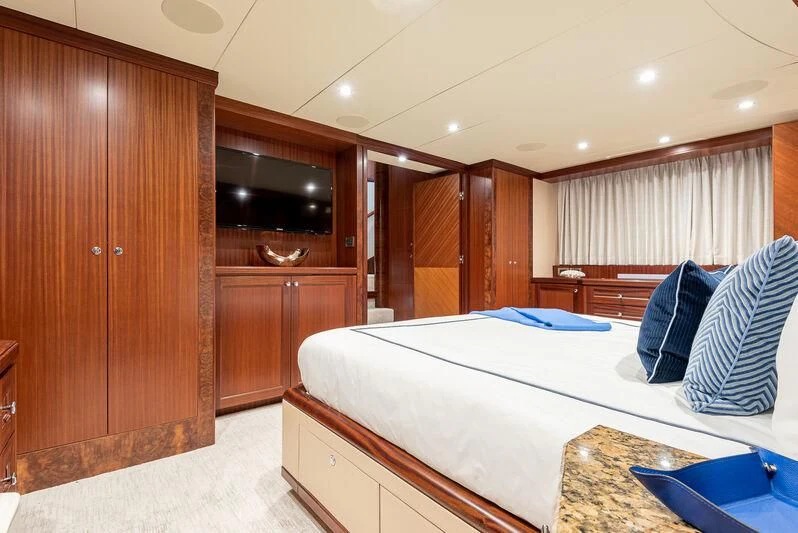 a bedroom with a bed and a wood cabinet aboard RHYTHM'N BLUES Yacht for Sale