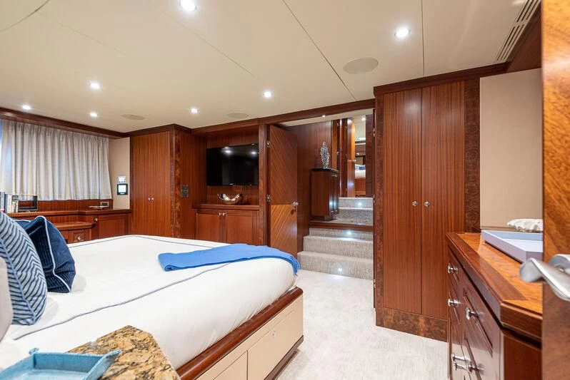 a bedroom with a bed and a wood cabinet aboard RHYTHM'N BLUES Yacht for Sale