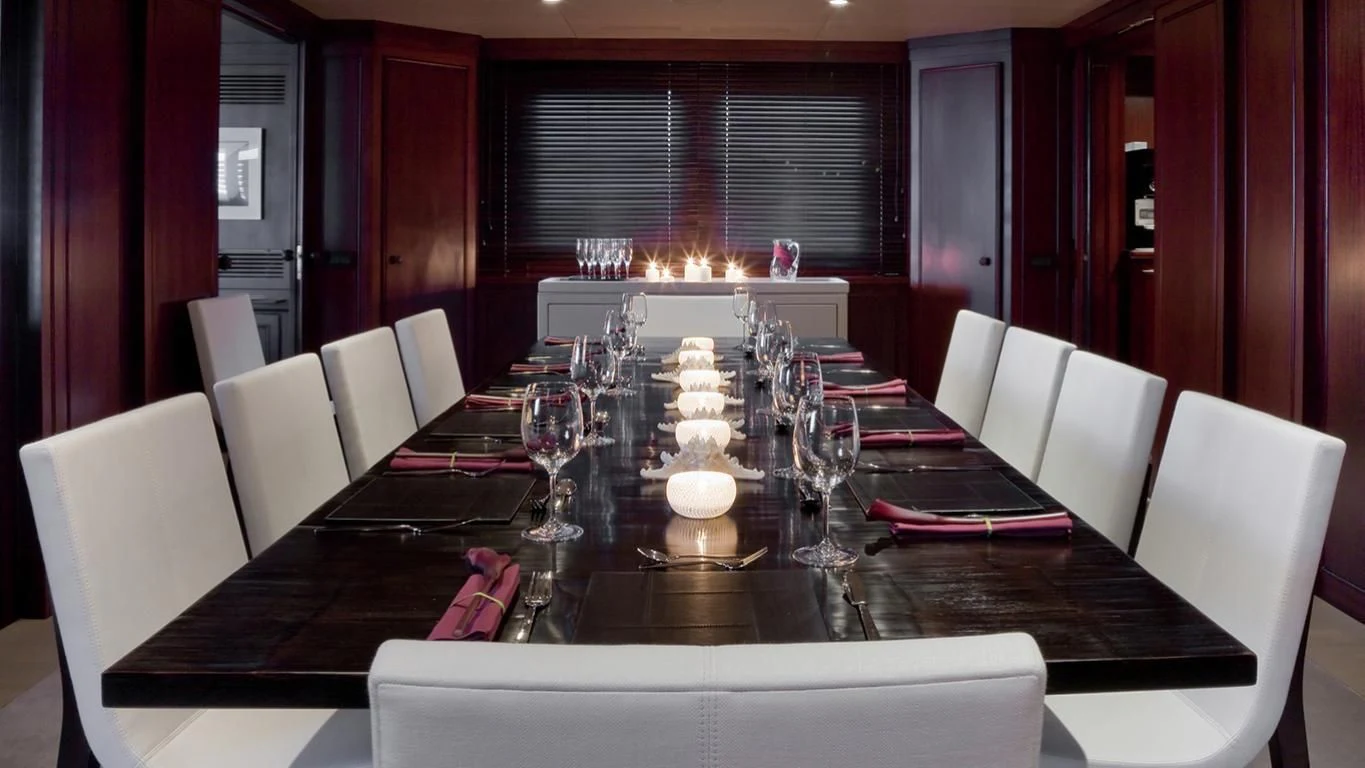 a dining room table set for a dinner party aboard CYAN Yacht for Sale