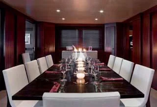 a large room with a table and chairs aboard CYAN Yacht for Sale