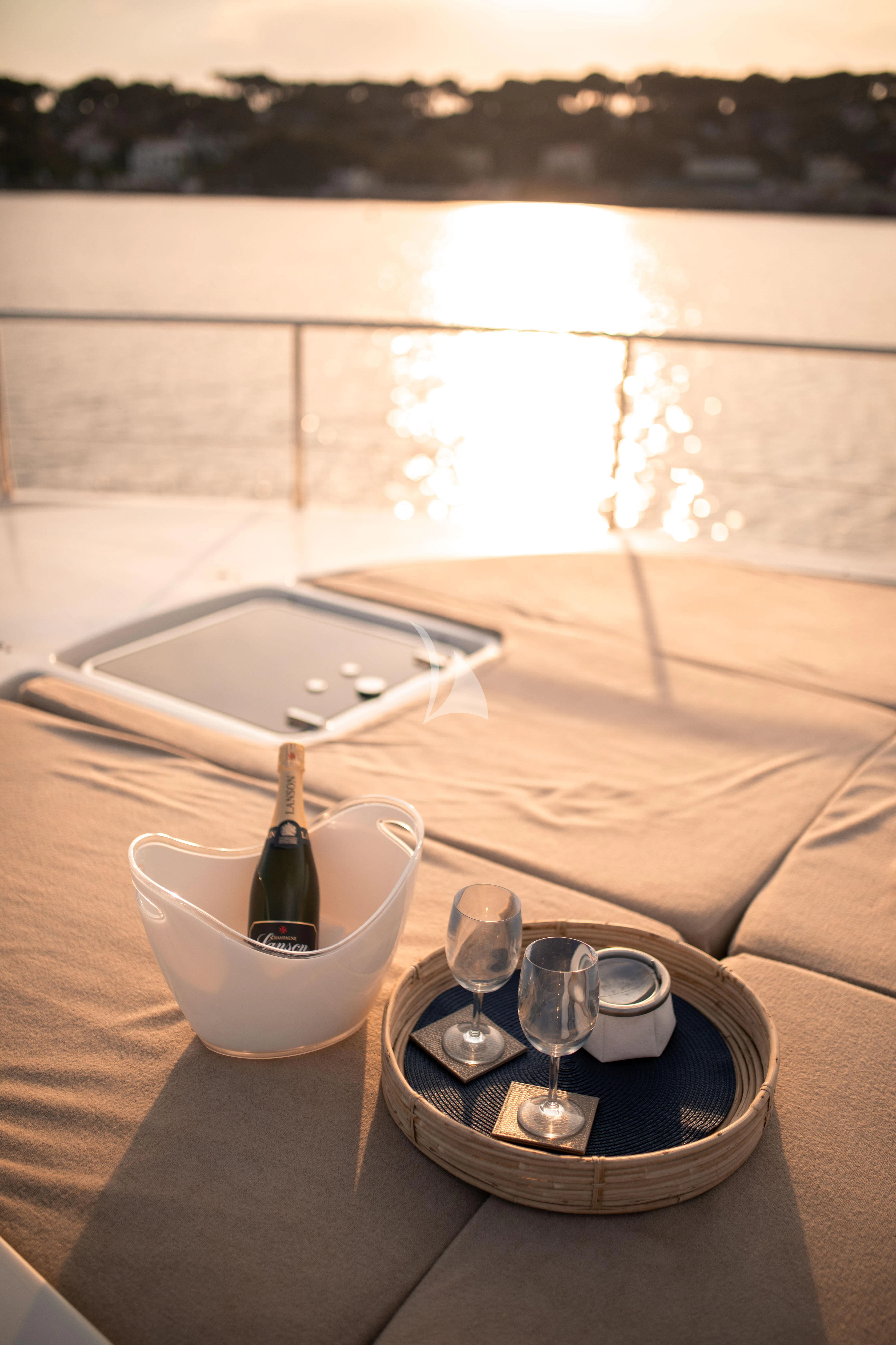 a glass bottle and a glass of wine on a table aboard ELLERY A Yacht for Sale