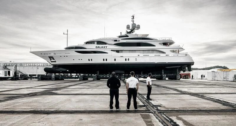 a group of men standing in front of a large ship aboard GALAXY Yacht for Sale