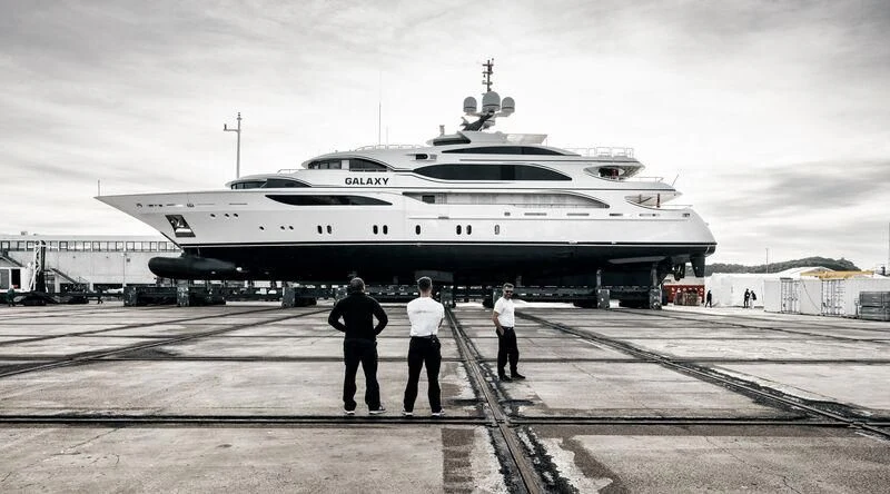 a group of men standing next to a large airplane aboard GALAXY Yacht for Sale