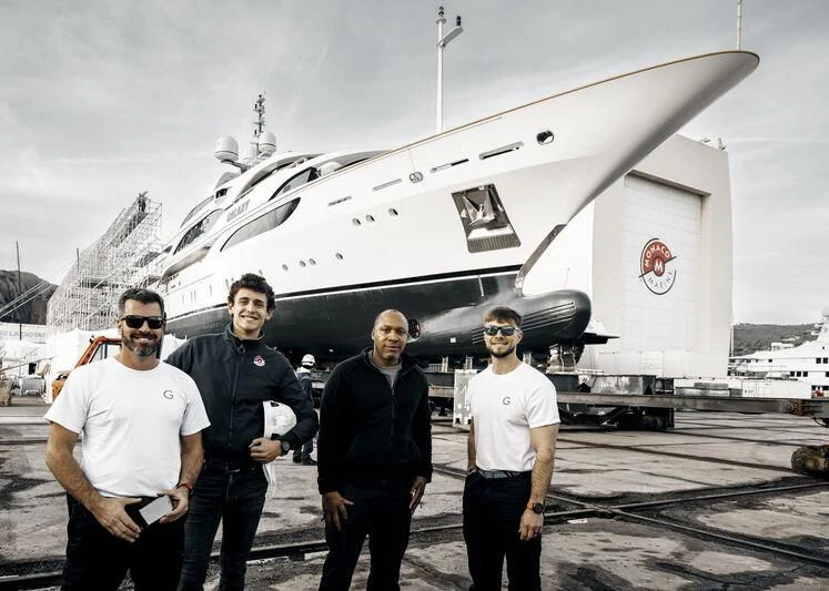 a group of men posing in front of a large aircraft aboard GALAXY Yacht for Sale