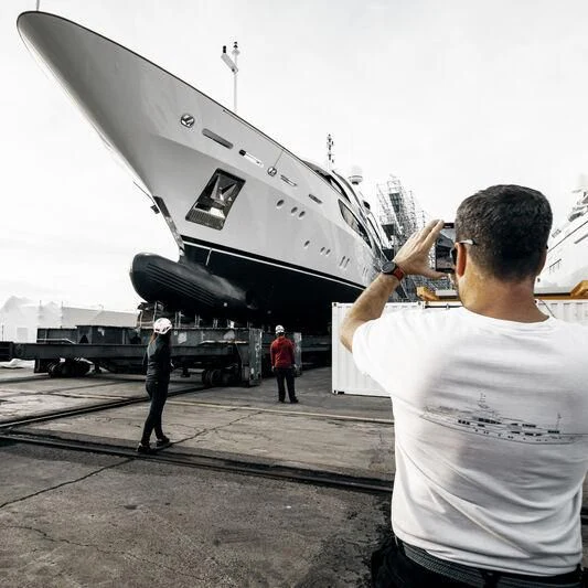 a man taking a picture of a plane aboard GALAXY Yacht for Sale