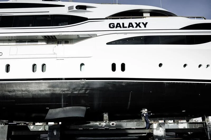 a person standing next to a large white airplane aboard GALAXY Yacht for Sale