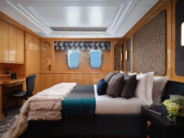 a bedroom with a bed and a table aboard GALAXY Yacht for Sale