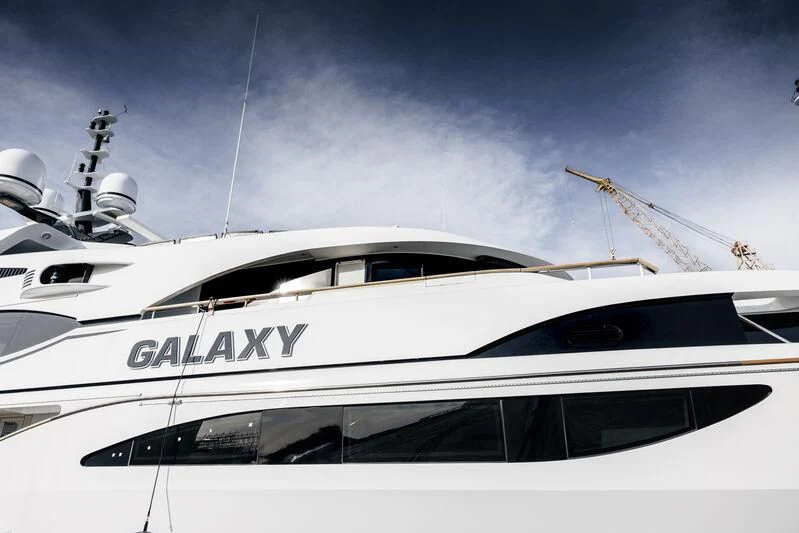 a white yacht with a crane in the background aboard GALAXY Yacht for Sale