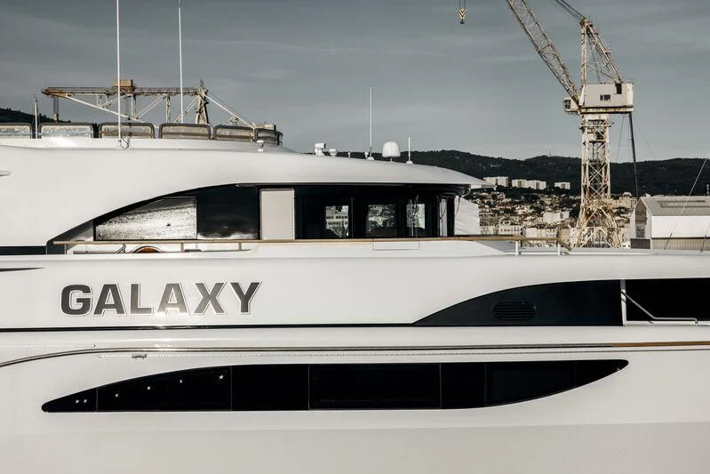 a white boat with a crane in the background aboard GALAXY Yacht for Sale