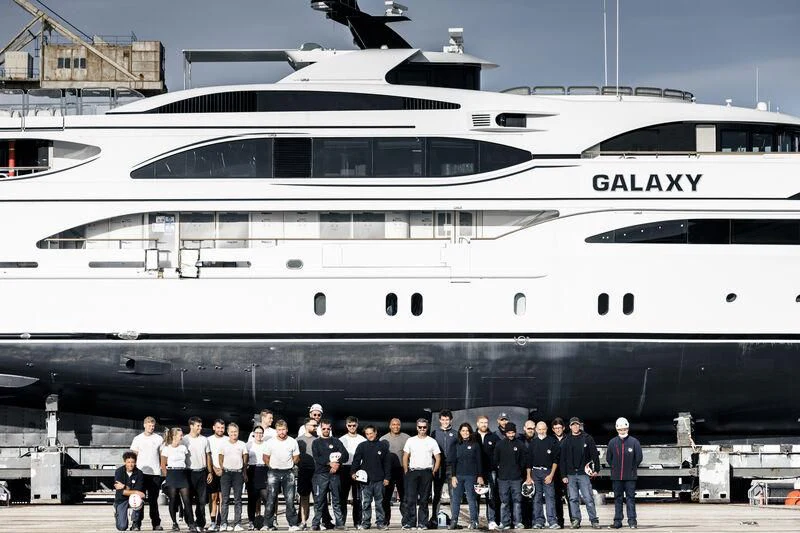 a group of people standing in front of a large cruise ship aboard GALAXY Yacht for Sale