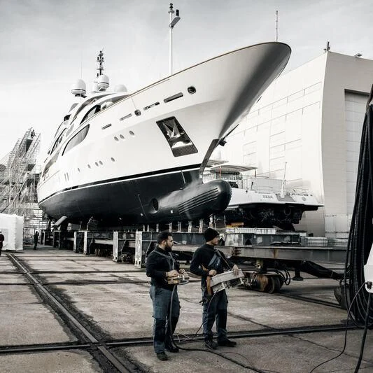 a group of people standing next to a large plane aboard GALAXY Yacht for Sale
